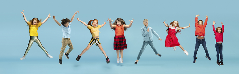 Image showing Little and happy kids gesturing isolated on blue studio background. Human emotions, facial expression concept