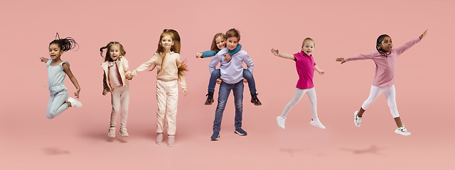 Image showing Little and happy kids gesturing isolated on pink studio background. Human emotions, facial expression concept