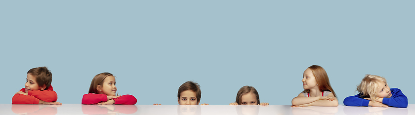 Image showing Little and happy kids gesturing isolated on blue studio background. Human emotions, facial expression concept