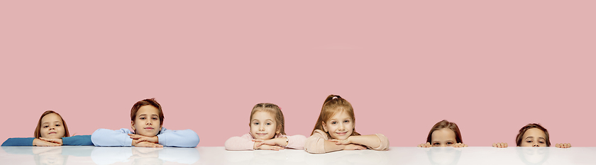 Image showing Little and happy kids gesturing isolated on pink studio background. Human emotions, facial expression concept