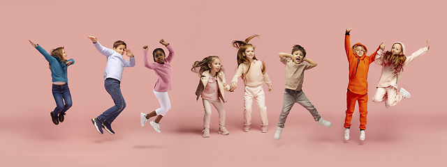 Image showing Little and happy kids gesturing isolated on pink studio background. Human emotions, facial expression concept