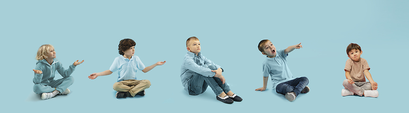 Image showing Little and happy kids gesturing isolated on blue studio background. Human emotions, facial expression concept