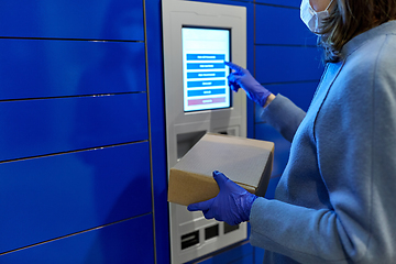 Image showing woman in mask with box at parcel machine