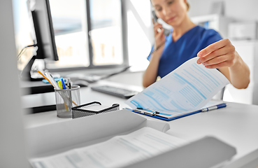 Image showing doctor with computer calling on phone at hospital