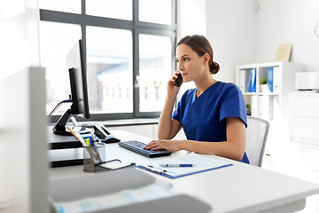 Image showing doctor with computer calling on phone at hospital