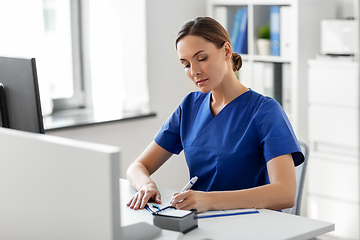 Image showing doctor or nurse with clipboard working at hospital