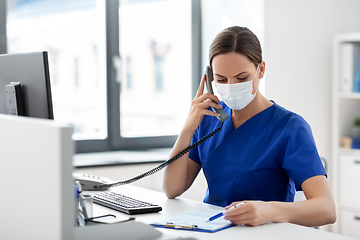 Image showing doctor with computer calling on phone at hospital