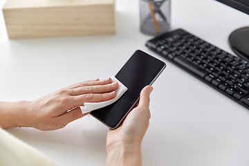 Image showing close up of hands cleaning smartphone with tissue