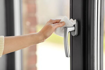 Image showing woman cleaning window handle with wet wipe