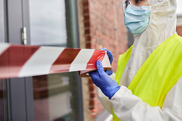 Image showing healthcare worker sealing door with caution tape