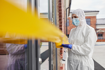 Image showing healthcare worker sealing door with caution tape