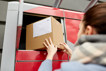 Image showing woman putting box to automated parcel machine