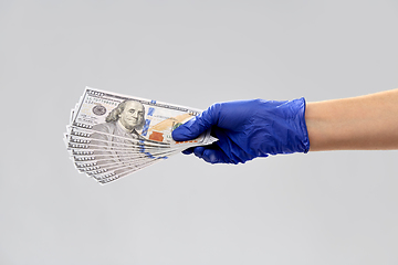 Image showing close up of hand in medical glove with money