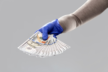 Image showing close up of hand in medical glove with money