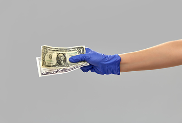 Image showing close up of hand in medical glove with money