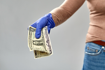 Image showing close up of hand in medical glove with money