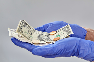 Image showing close up of hands in medical gloves with money