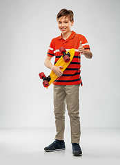 Image showing smiling boy with short skateboard