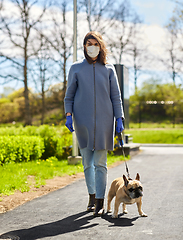 Image showing woman in mask and gloves with dog walking in city