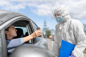 Image showing woman in car showing phohe to healthcare worker