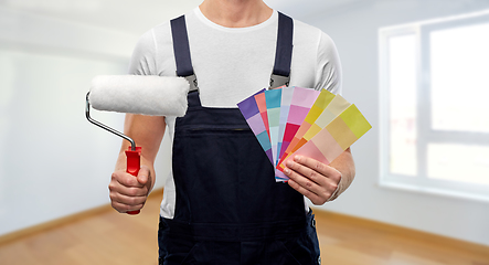 Image showing close up of painter with roller and color charts