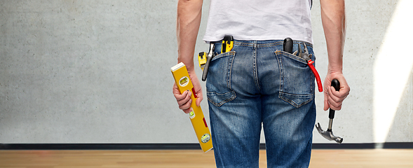 Image showing man with level and working tools in pockets