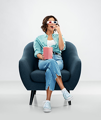 Image showing woman in 3d movie glasses eating popcorn in chair