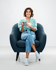 Image showing woman sitting in chair with cup of coffee or tea