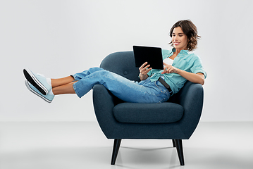 Image showing happy woman with tablet pc sitting in armchair