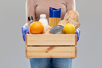 Image showing woman in gloves with food in wooden box