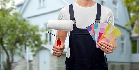 Image showing close up of painter with roller and color charts