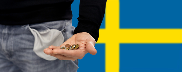 Image showing close up of man showing coins and empty pockets