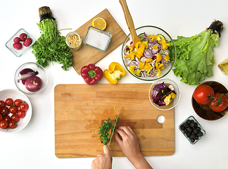 Image showing hands chopping parsley for salad at kitchen