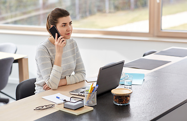 Image showing young woman calling on smartphone at home office