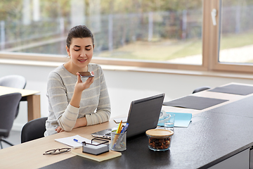 Image showing woman with smartphone recording voice at office