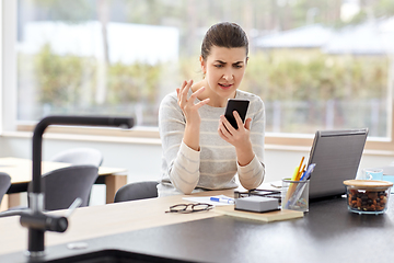 Image showing angry woman calling on smartphone at home office