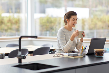 Image showing woman with laptop and coffee working at home