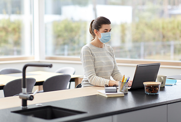 Image showing woman in mask with laptop working at home office