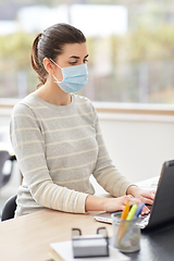 Image showing woman in mask with laptop working at home office