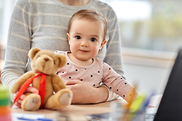 Image showing happy baby with mother working at home office