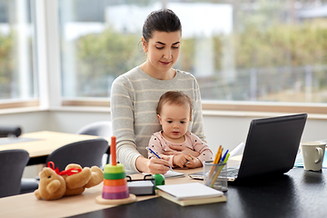 Image showing mother with baby working at home office