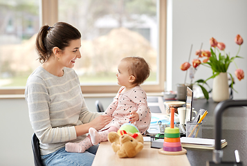 Image showing happy mother with baby working at home office