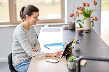 Image showing young woman with tablet pc working at home office