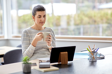 Image showing young woman with tablet pc working at home office