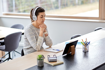 Image showing woman in headphones with tablet pc working at home