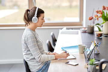 Image showing woman in headphones with tablet pc working at home