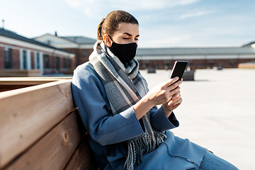 Image showing woman in face mask with smartphone in city