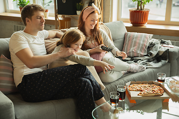 Image showing Family spending nice time together at home, looks happy and cheerful, eating pizza