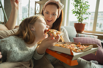 Image showing Family spending nice time together at home, looks happy and cheerful, eating pizza. Close up.