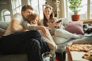 Image showing Family spending nice time together at home, looks happy and cheerful, eating pizza